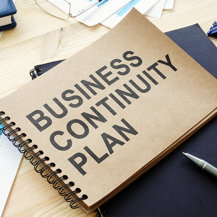 A big book on a desk with the title Business Continuity Plan