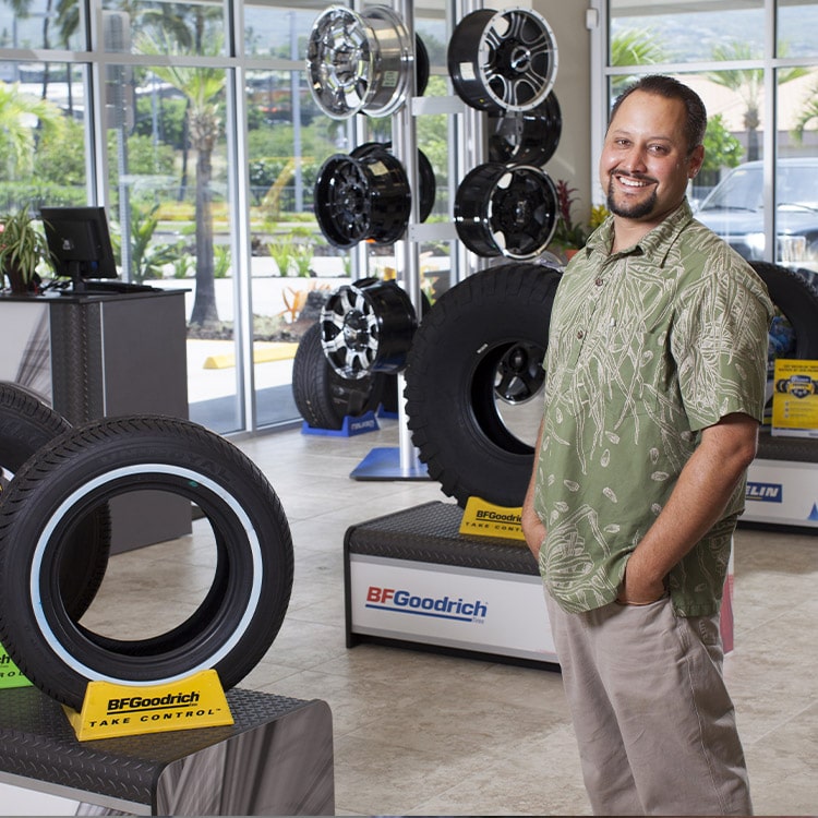 A man standing in a tire shop.