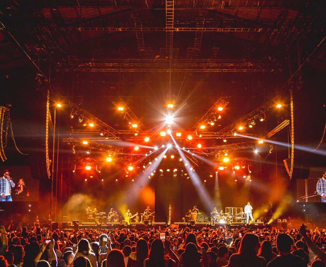 A vibrant concert crowd illuminated by dazzling lights.