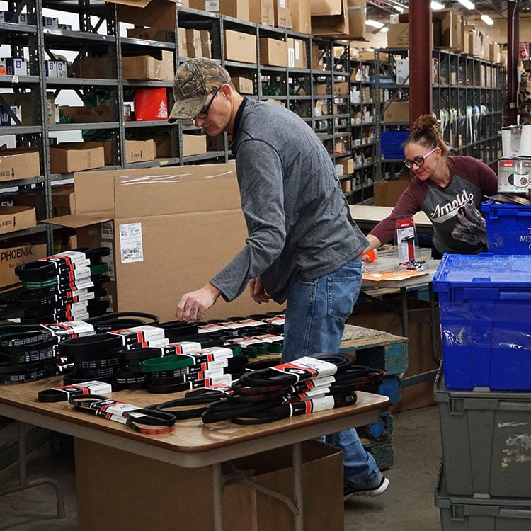 Two workers in an Irish warehouse organising numerous boxes and crates.