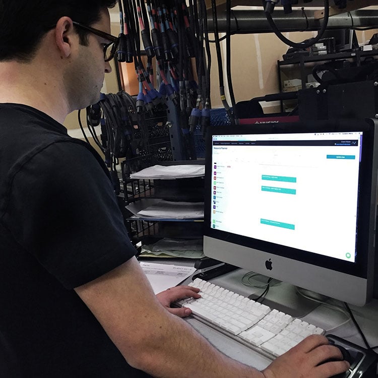 A man in a black shirt intently working on a computer, customising a quote.