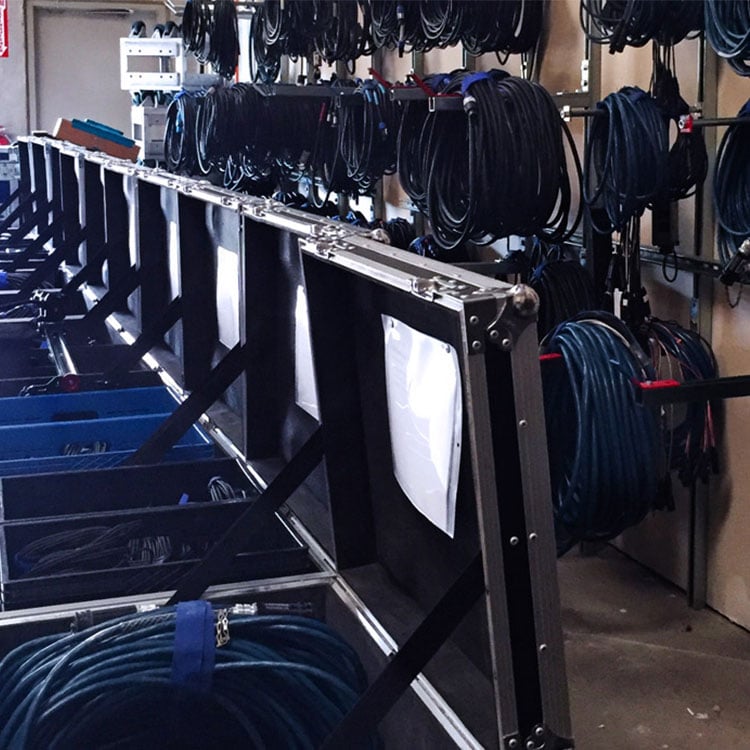 A warehouse filled with a vast rack of cables neatly organized, ready for use in various electronic systems.