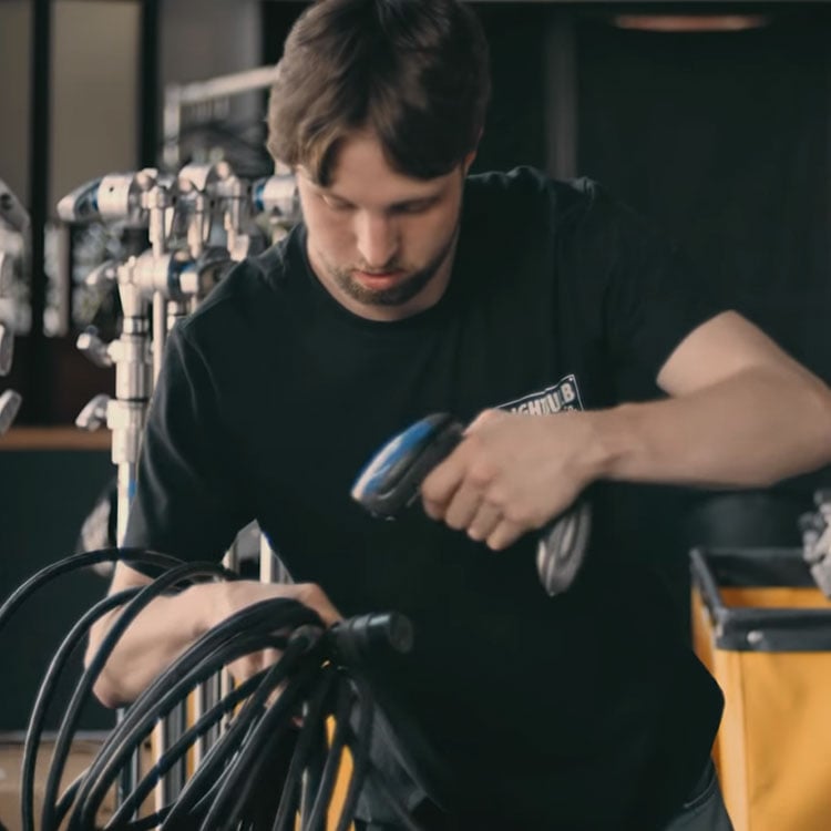 A man in an Irish warehouse operating a device for equipment scanning.