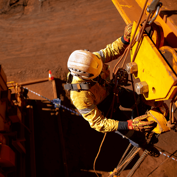 A worker operating massive machinery in a construction site.