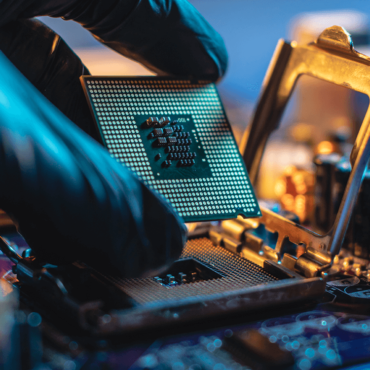 A person holding a processor chip on a motherboard, showcasing the intricate connection between hardware components.