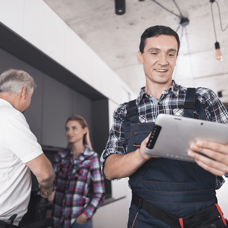 A man in overalls holding a tablet computer, looking at a sales quotation