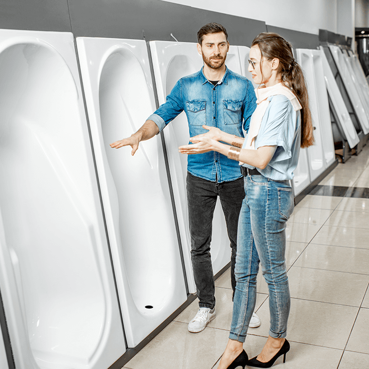 A man and woman inspecting bathtubs in a store in Ireland.