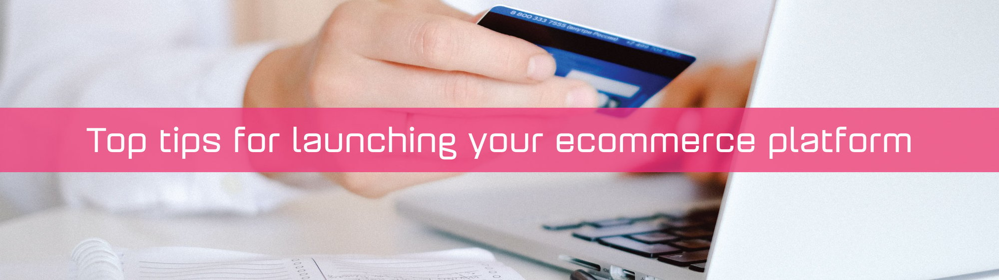 A hand holding a credit card infront of a laptop with a strap saying Top tips for launching your ecommerce website