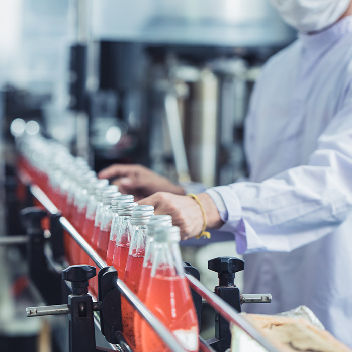 A worker in a white lab coat diligently working on a production line, ensuring quality and efficiency.