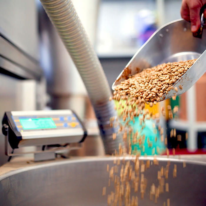 Person pouring grain into a large bowl at an Irish plant.