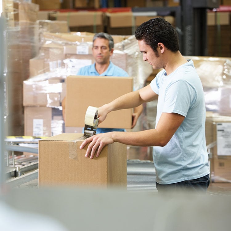 A man sealing a cardboard box