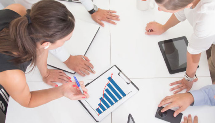 A team of employees looking at a graph