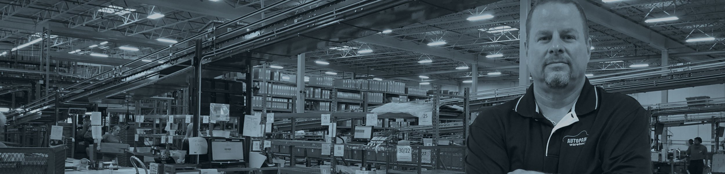 A man crossing his arms standing in a warehouse