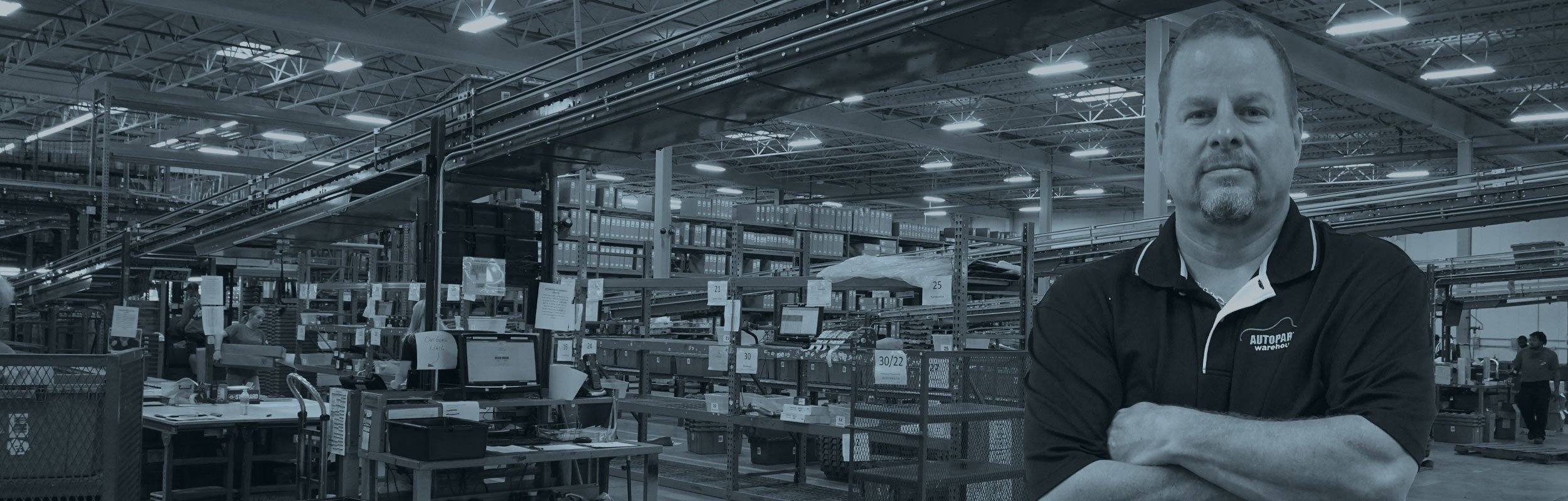 A man crossing his arms standing in a warehouse