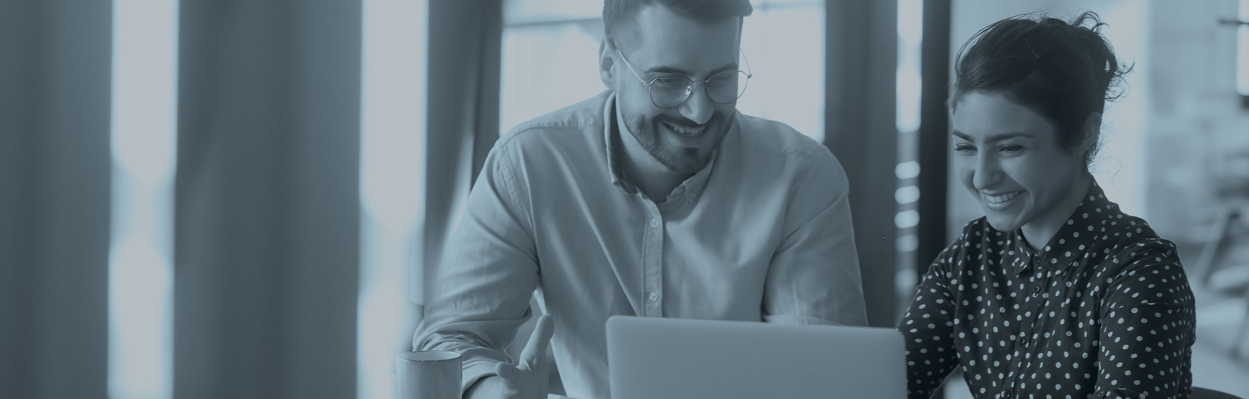 Two happy employees looking at a computer sreen