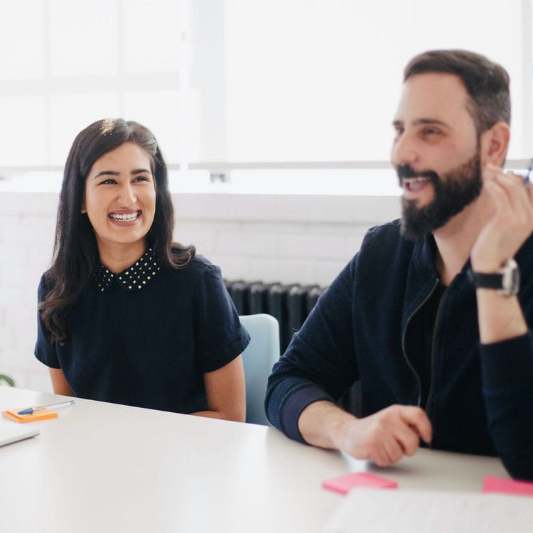 Two happy employees engaged in a conversation.