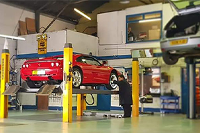 Motorepair garage with two cars in for repairs